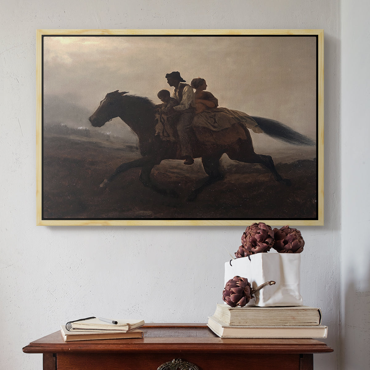 Natural wood floater framed canvas featuring A Ride for Liberty – The Fugitive Slaves, c. 1862 by Eastman Johnson above an entryway table in a minimalist foyer.