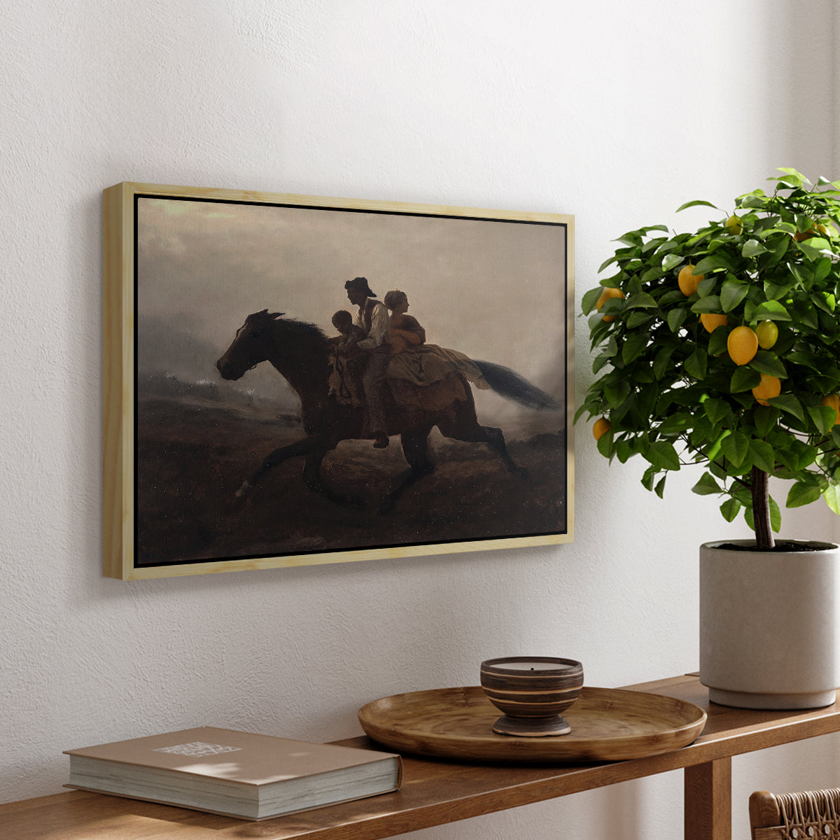A Ride for Liberty – The Fugitive Slaves, c. 1862 by Eastman Johnson, presented in a natural wood floater framed canvas featuring a family riding horseback through night escaping across landscape, displayed above a hallway console table.