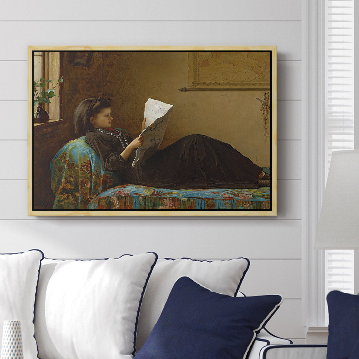 Interesting News, 1872 by Eastman Johnson displayed above a sofa in a living room in a natural wood floater frame, featuring a domestic scene with figures reacting to shared news.