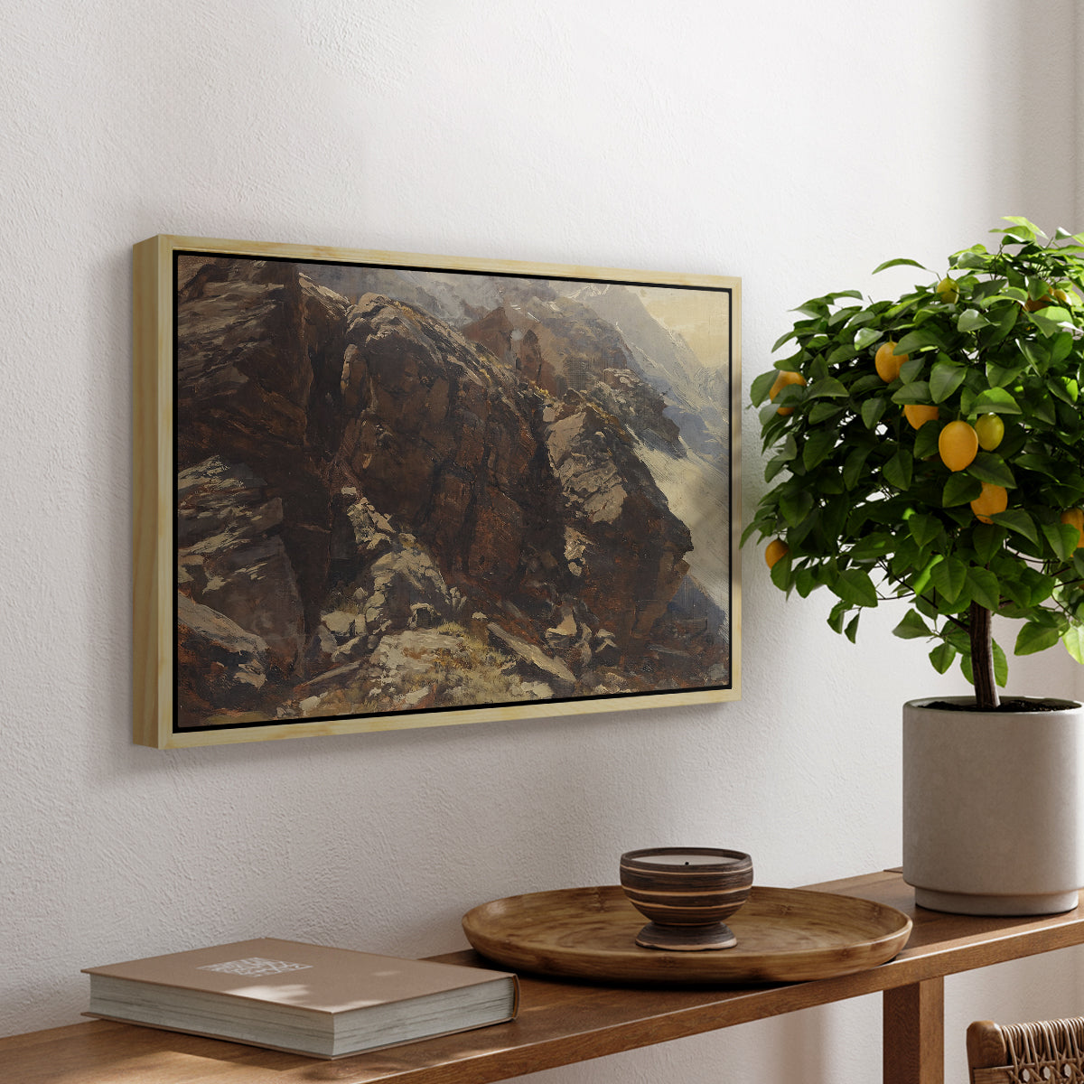 High Mountain Study, c. 1870 by Edward Theodore Compton, presented in a natural wood floater framed canvas featuring a rocky alpine terrain with steep slopes and distant mountain peaks, displayed above a hallway console table.