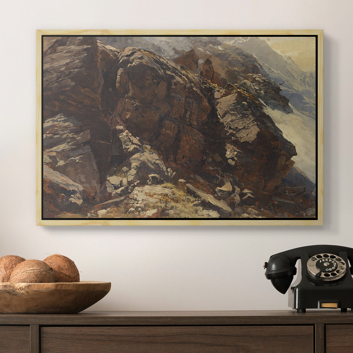 High Mountain Study, c. 1870 by Edward Theodore Compton in a natural wood floater framed canvas displayed above a console table in a hallway, featuring a realistic depiction of mountainous terrain under open sky.