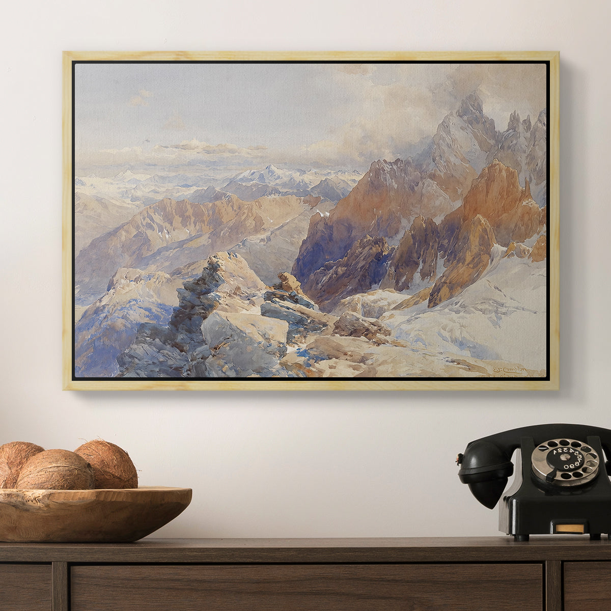 Col du Géant, 1903 by Edward Theodore Compton in a natural wood floater framed canvas displayed above a console table in a hallway, featuring a rugged mountain pass scene with distant peaks.