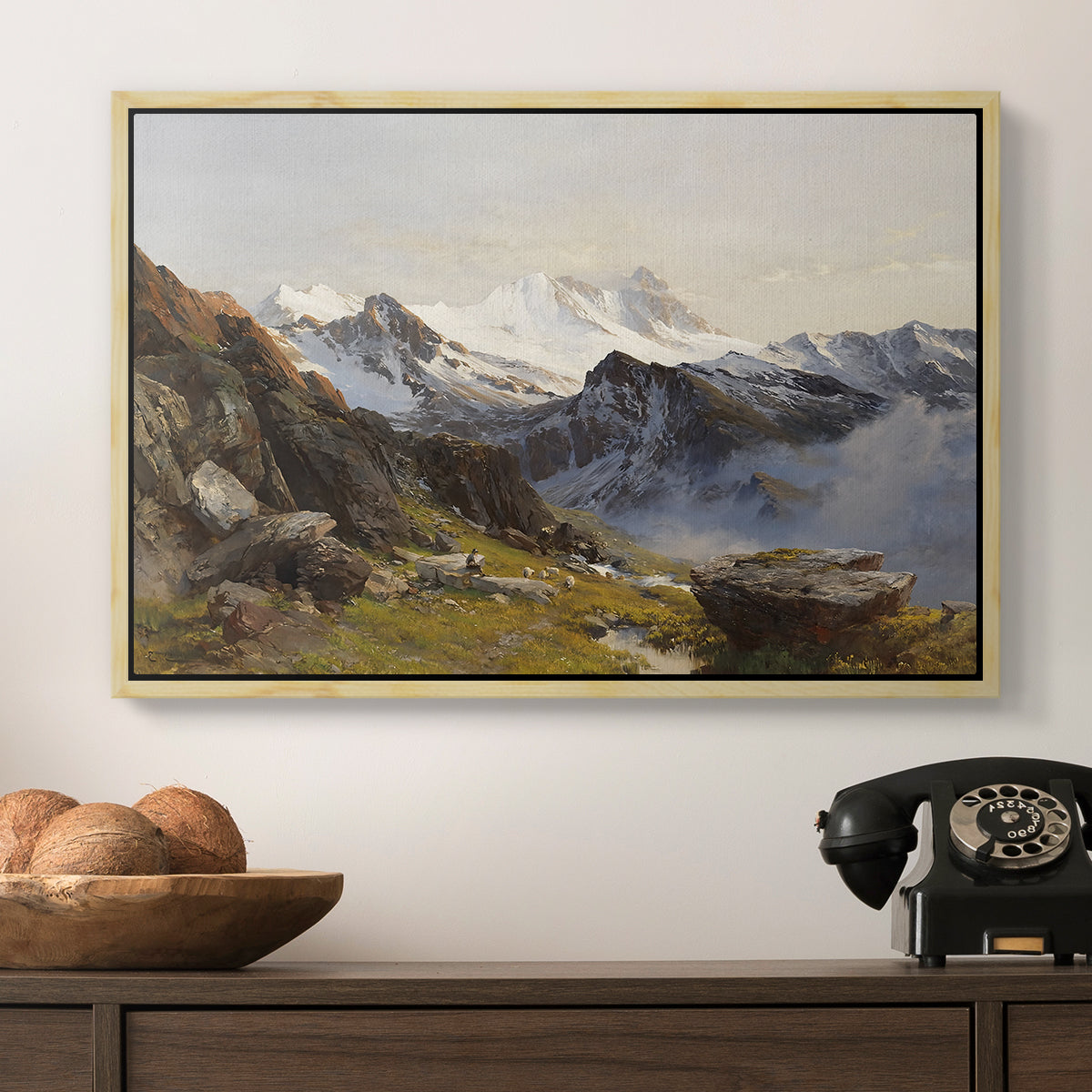 The Großglockner from the Prager Hut, 1890 by Edward Theodore Compton in a natural wood floater framed canvas displayed above a console table in a hallway, featuring a scenic mountain view with dramatic elevation and depth.