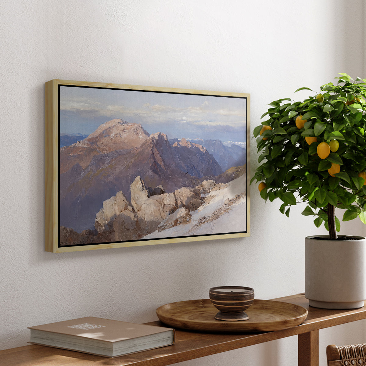 Hoher Göll from Watzmann-Hocheck, 1919 by Edward Theodore Compton, presented in a natural wood floater framed canvas featuring a distant mountain peak viewed from elevated ridge with sweeping landscape, displayed above a hallway console table.