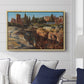 Palatine in Rome, c. 1921 by Edward Theodore Compton displayed above a sofa in a living room in a natural wood floater frame, featuring an architectural scene of ancient structures in sunlit environment.