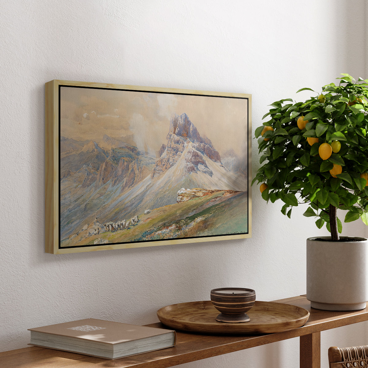 From the Dolomites, 1904 by Edward Theodore Compton, presented in a natural wood floater framed canvas featuring dramatic Dolomite mountain peaks rising above rugged terrain, displayed above a hallway console table.