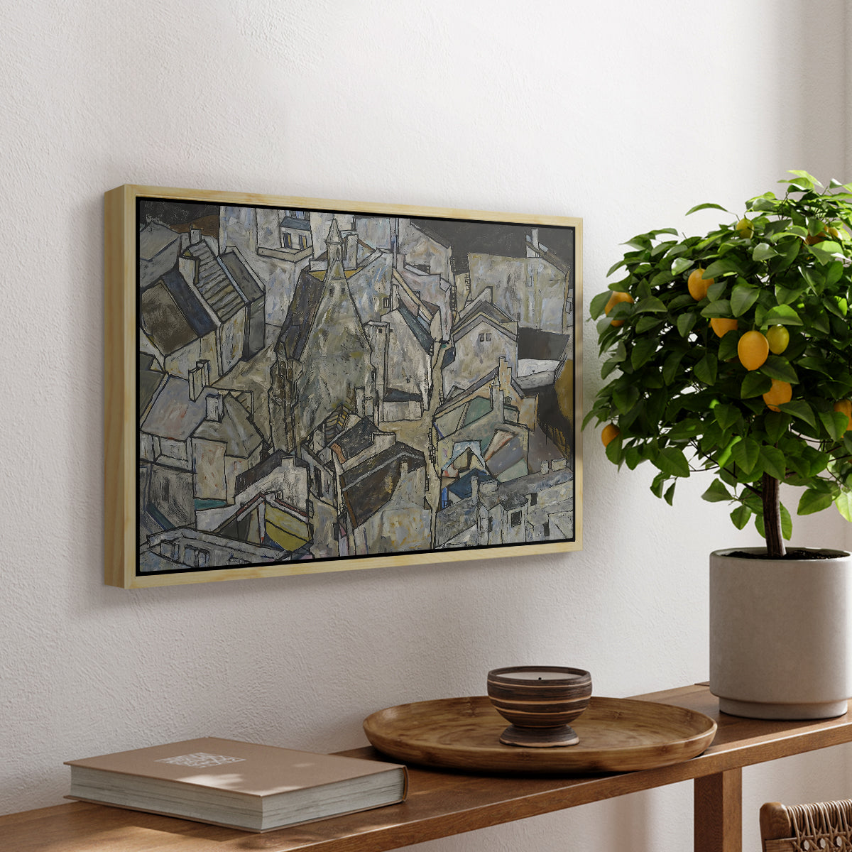 Mödling II, 1918 by Egon Schiele, presented in a natural wood floater framed canvas featuring clustered geometric houses forming dense urban landscape with sharp angles, displayed above a hallway console table.
