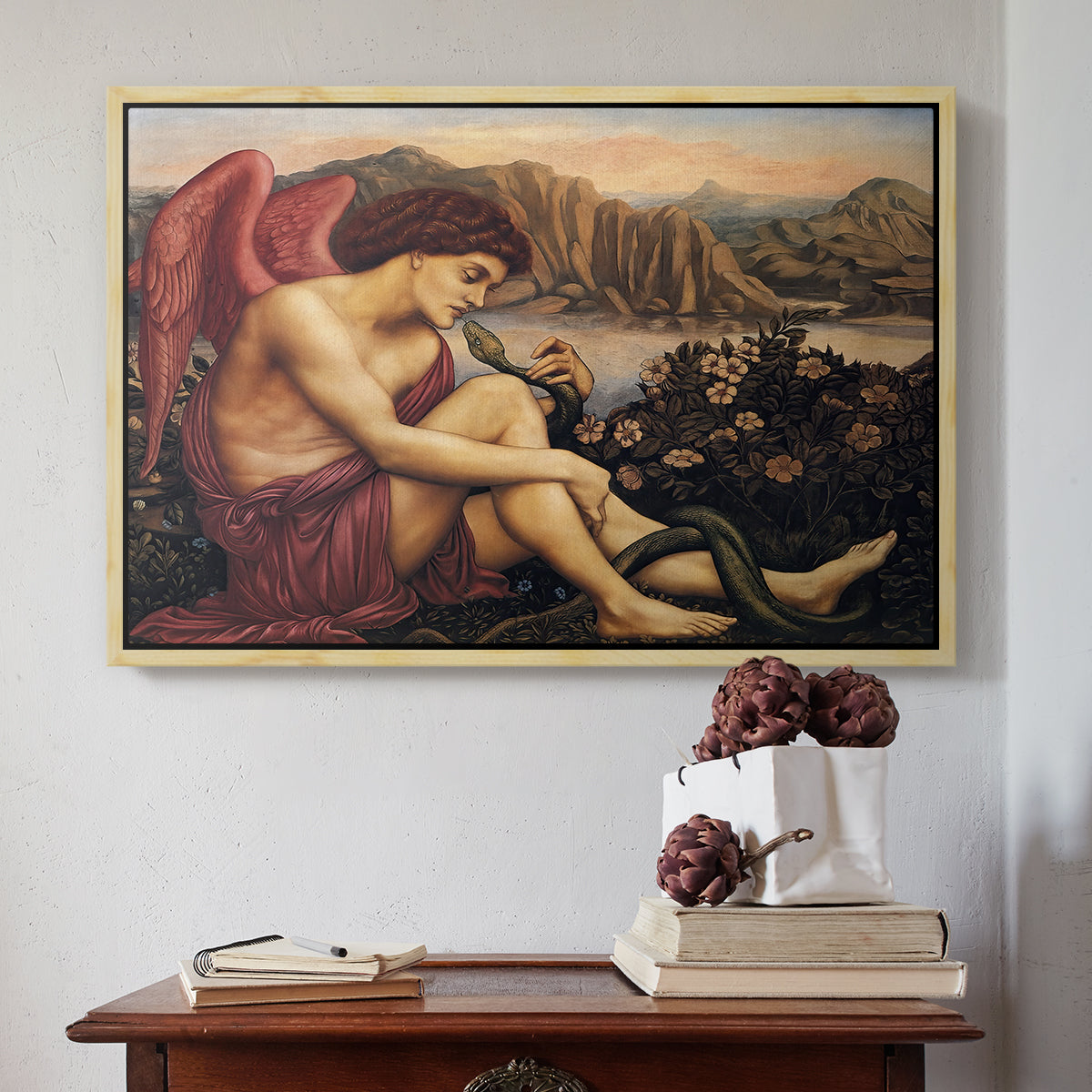 Natural wood floater framed canvas featuring The Angel with the Serpent, c. 1870-1875 by Evelyn De Morgan above an entryway table in a minimalist foyer.