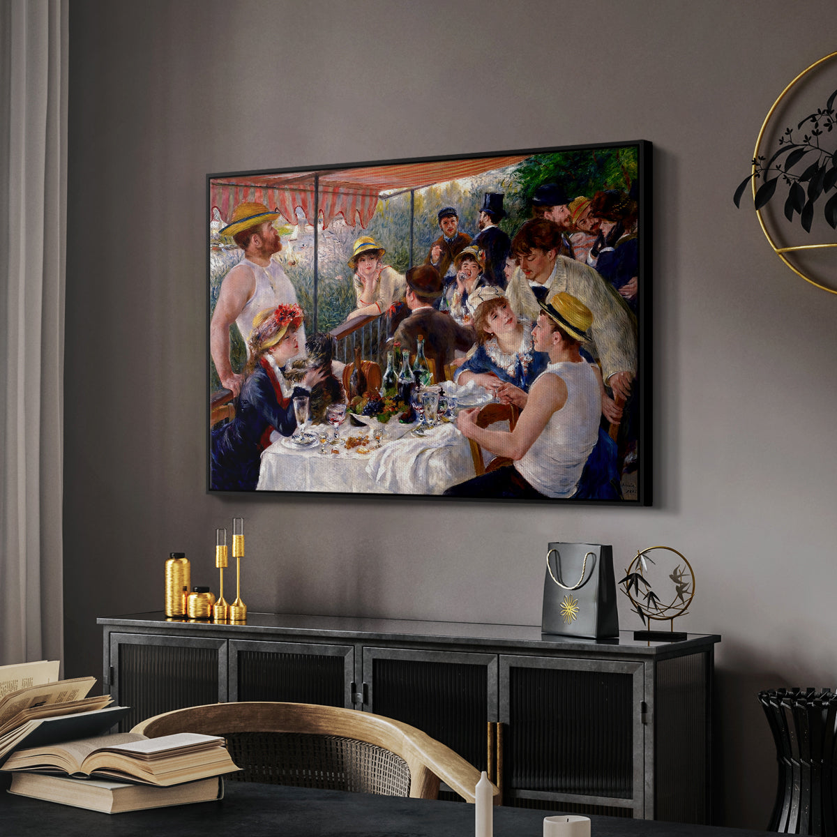 Luncheon of the Boating Party (Le Déjeuner des canotiers), 1880-1881 by Pierre-Auguste Renoir in a black floater framed canvas featuring an impressionist scene of friends enjoying lunch with wine and conversation, displayed above a desk in a dark home office interior.