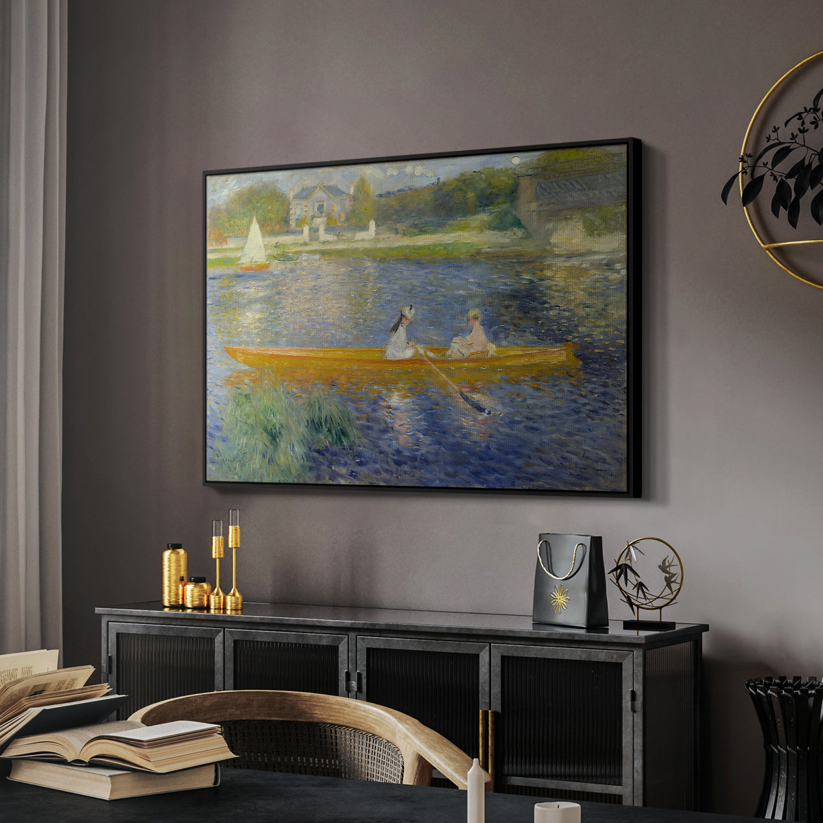 The Skiff (La Yole), 1875 by Pierre-Auguste Renoir in a black floater framed canvas featuring a couple seated in boat on river surrounded by soft reflections, displayed above a desk in a dark home office interior.