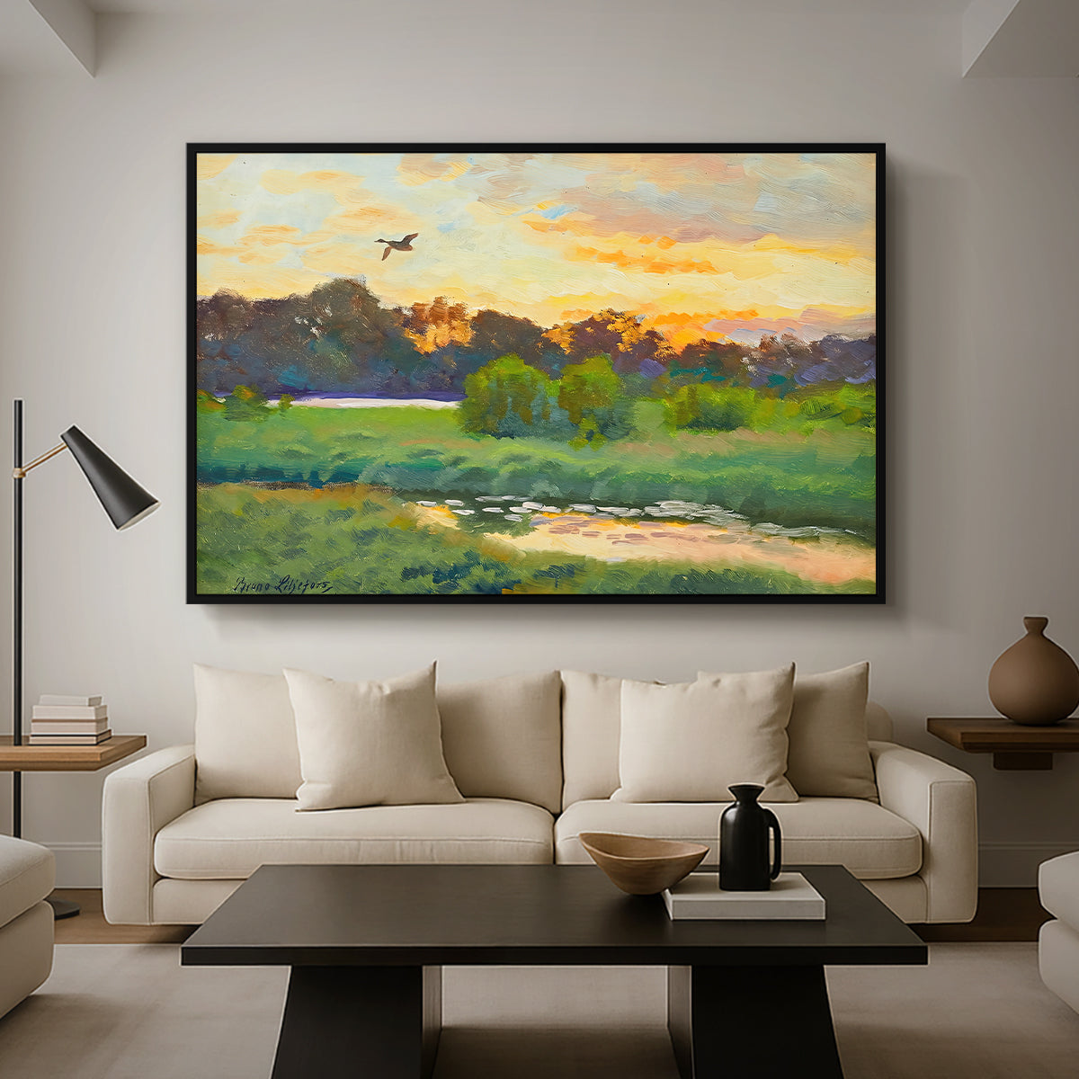 Flying Duck at Sunset, 1924 by Bruno Liljefors as a black floater framed canvas featuring a wild duck flying over a sunset marsh with trees, displayed above a sofa in a modern living room.