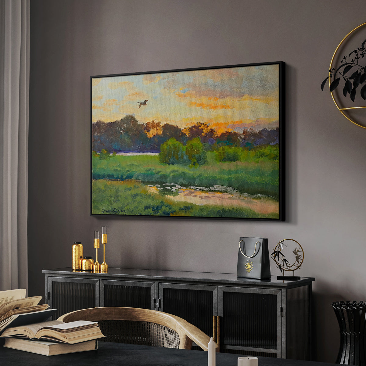 Flying Duck at Sunset, 1924 by Bruno Liljefors in a black floater framed canvas featuring a wild duck gliding through a golden sunset sky, displayed above a desk in a dark home office interior.