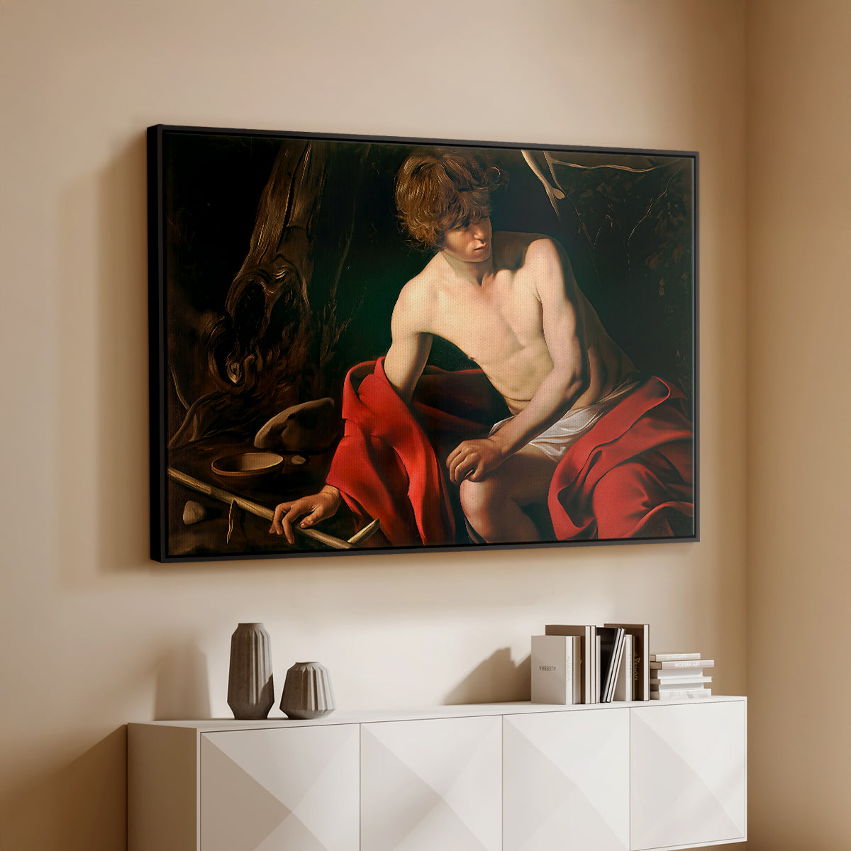Black floater framed canvas of Saint John the Baptist in the Wilderness, c. 1603-1604 by Caravaggio, featuring a solitary figure of Saint John resting in natural setting with soft light above a console cabinet in a minimalist entryway.