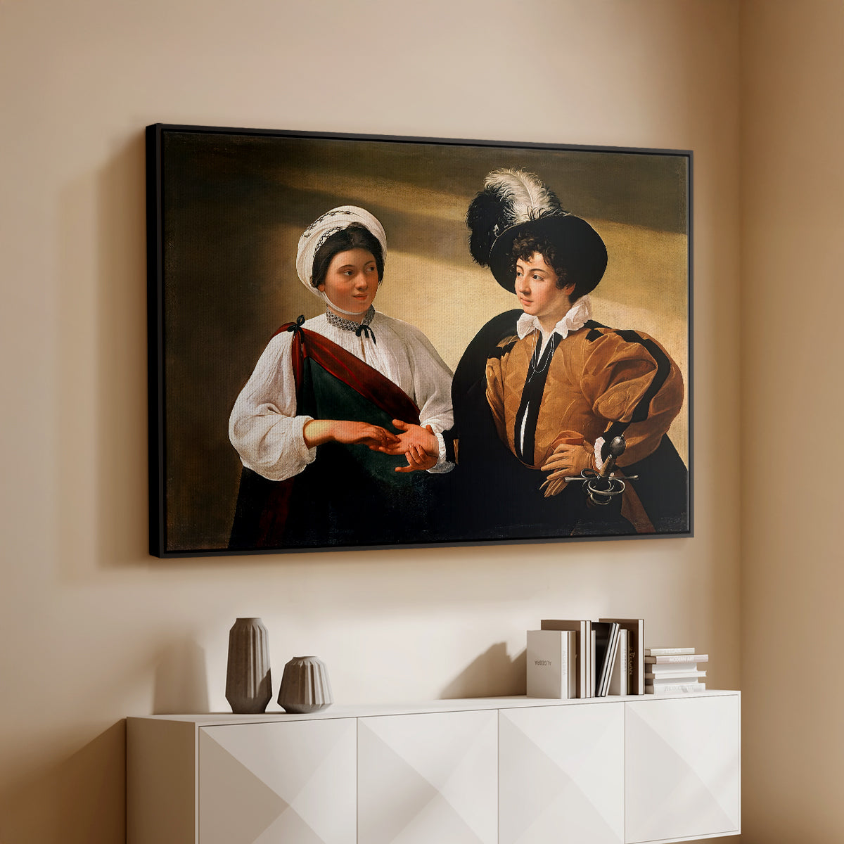 Black floater framed canvas of The Fortune Teller (Louvre Version), c. 1595 by Caravaggio, featuring a fortune teller examining hand of man as she slyly removes his ring above a console cabinet in a minimalist entryway.