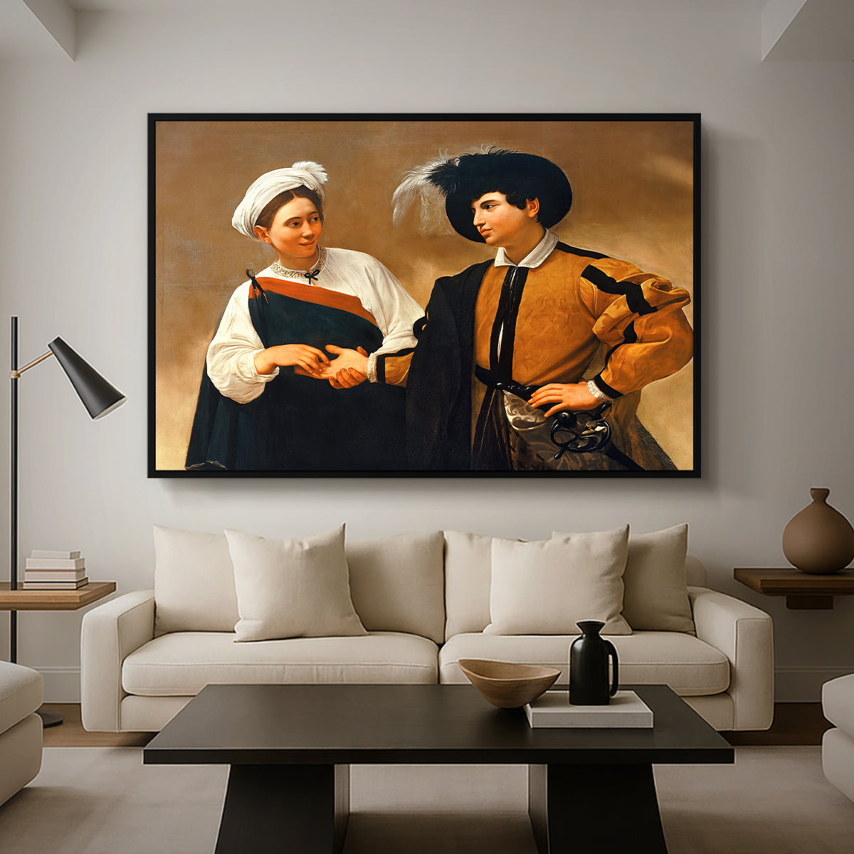 The Fortune Teller (Capitoline Version), c. 1599 by Caravaggio as a black floater framed canvas featuring a woman reading man's palm while discreetly removing his ring, displayed above a sofa in a modern living room.