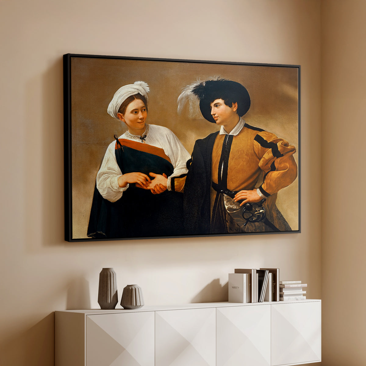 Black floater framed canvas of The Fortune Teller (Capitoline Version), c. 1599 by Caravaggio, featuring a fortune teller tricking young man during palm reading above a console cabinet in a minimalist entryway.