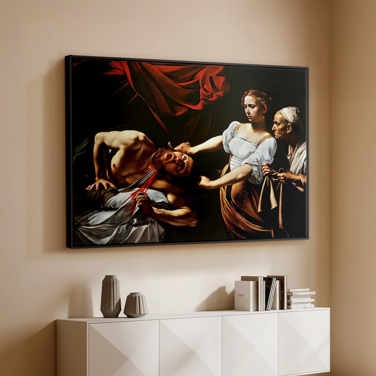 Black floater framed canvas of Judith Beheading Holofernes, c. 1599 by Caravaggio, featuring a dramatic biblical scene of woman beheading man in bed above a console cabinet in a minimalist entryway.