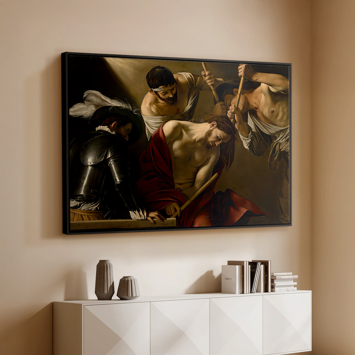 Black floater framed canvas of The Crowning with Thorns (Vienna Version), c. 1602-1604 by Caravaggio, featuring a biblical scene of Christ being mocked and crowned with thorns above a console cabinet in a minimalist entryway.