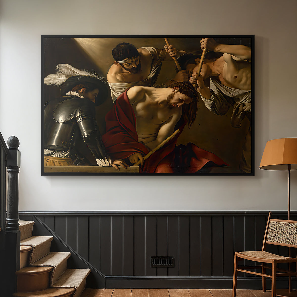 Black floater framed canvas featuring an intense religious composition with strong shadow and physical struggle, displayed in a hallway near a staircase.