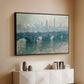 Black floater framed canvas of Waterloo Bridge, Gray Weather, 1900 by Claude Monet, featuring an impressionist cityscape with bridge fading into fog over water above a console cabinet in a minimalist entryway.