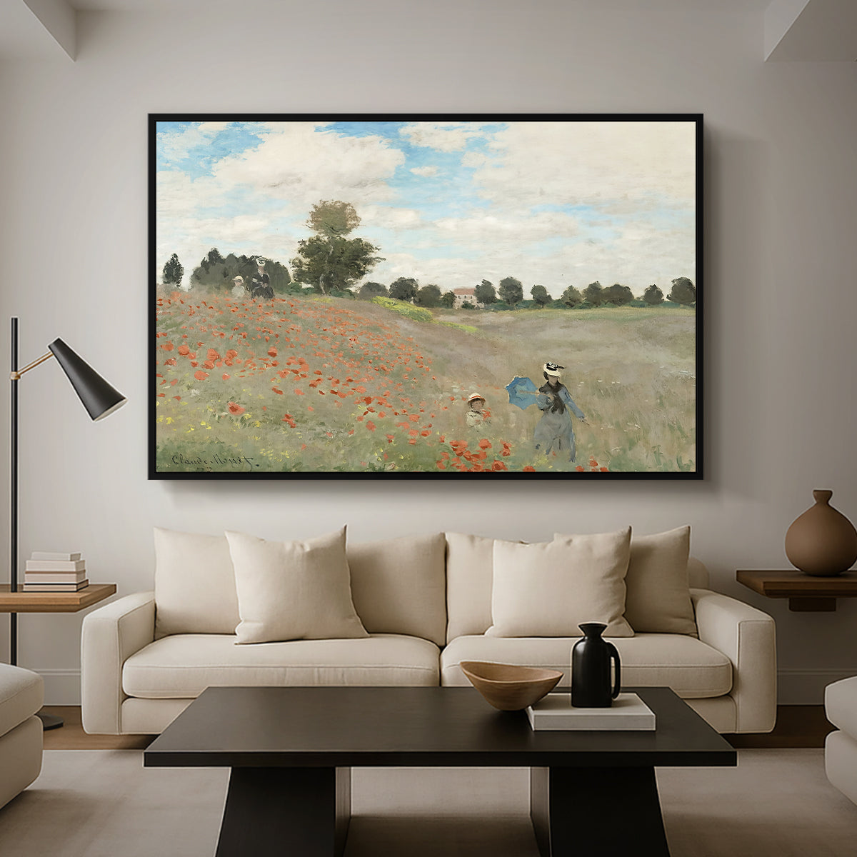 The Poppy Field near Argenteuil, 1873 by Claude Monet as a black floater framed canvas featuring a field of red poppies with figures walking across rolling landscape, displayed above a sofa in a modern living room.