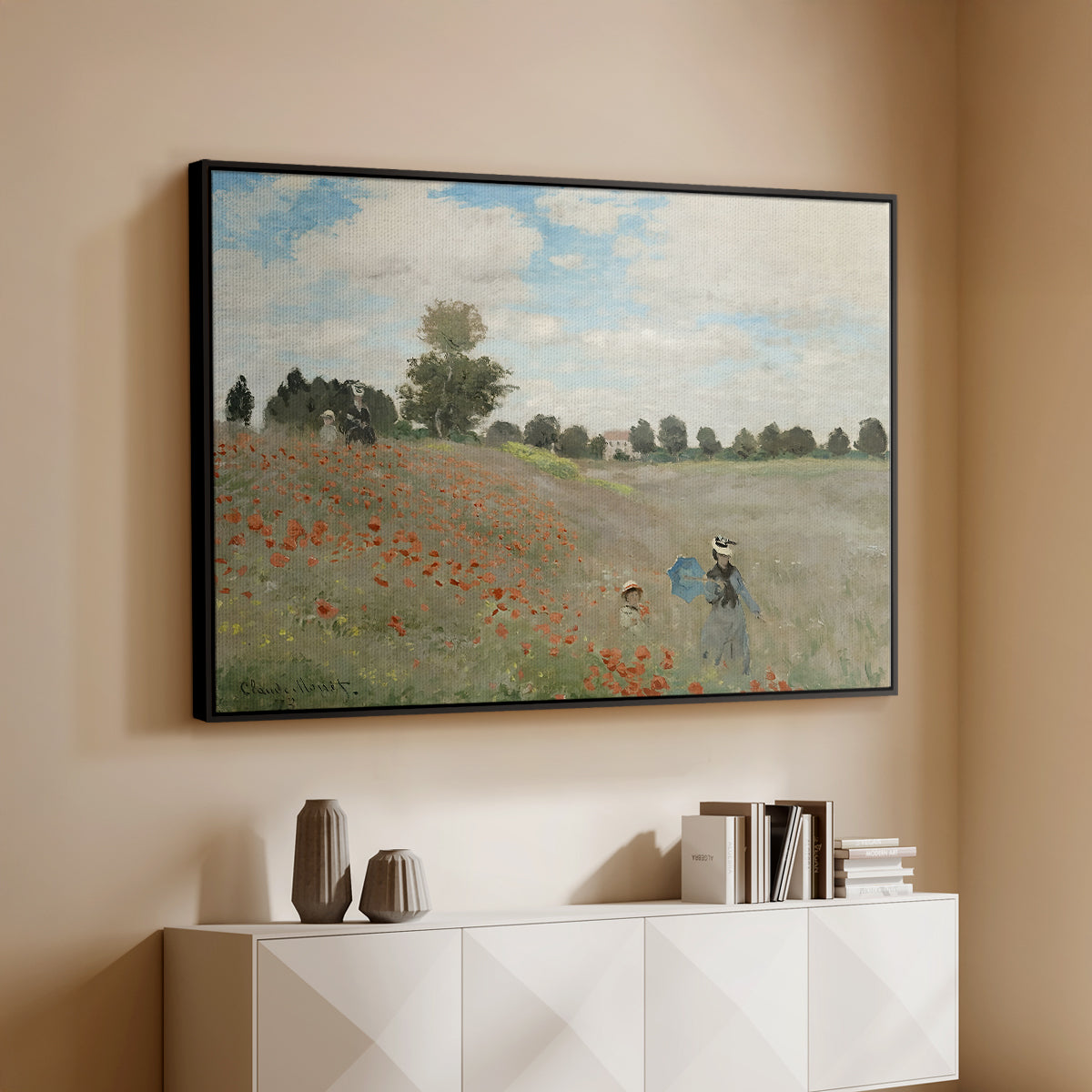Black floater framed canvas of The Poppy Field near Argenteuil, 1873 by Claude Monet, featuring an impressionist countryside scene with flowers and strolling figures above a console cabinet in a minimalist entryway.