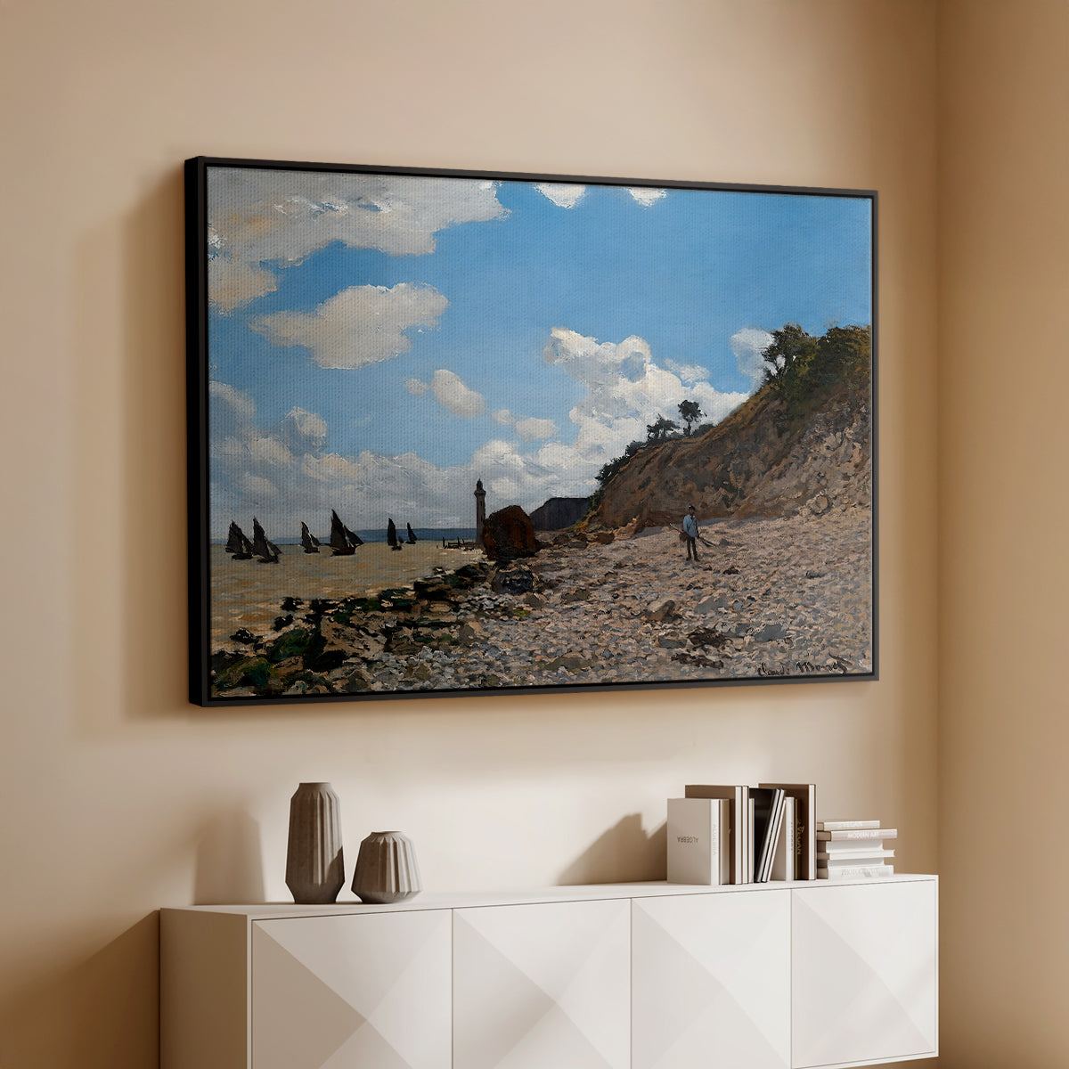Black floater framed canvas of The Beach at Honfleur, 1864 by Claude Monet, featuring an impressionist seaside with people and sailboats under bright sky above a console cabinet in a minimalist entryway.