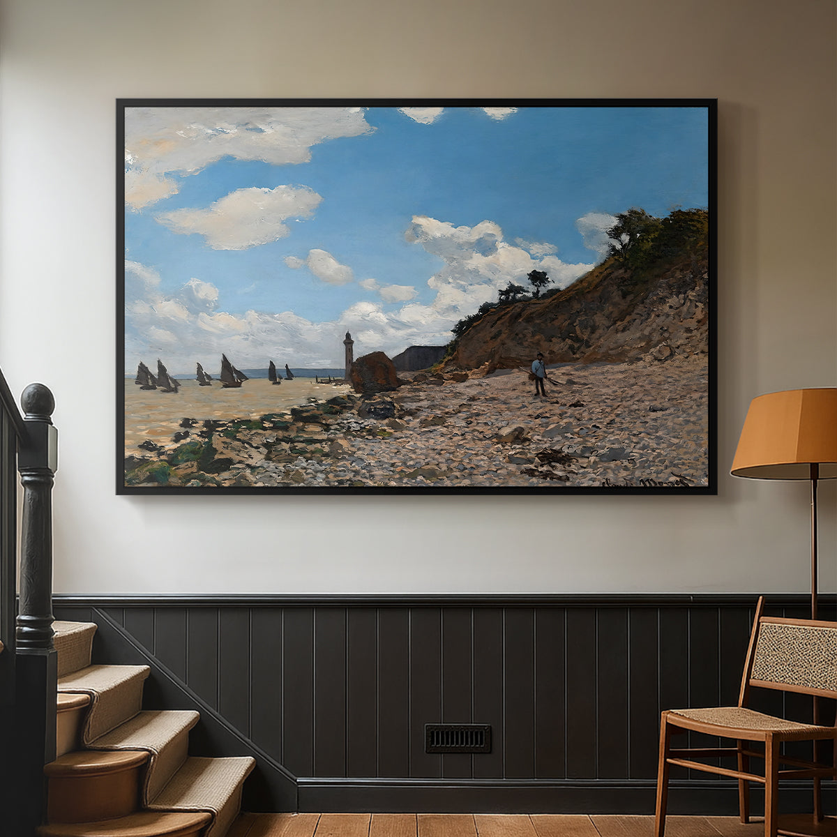Black floater framed canvas featuring a coastal landscape with boats and people along shore, displayed in a hallway near a staircase.