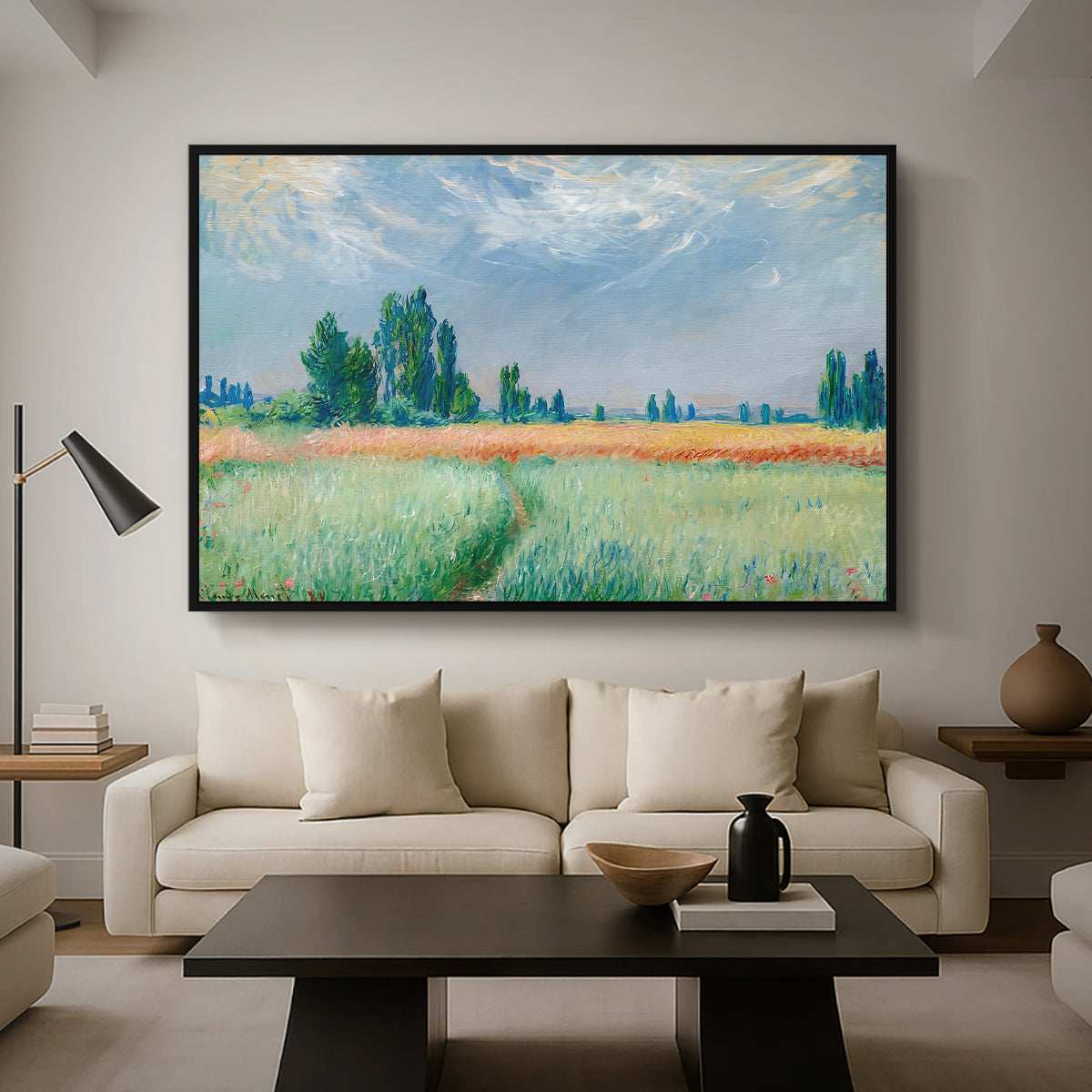 The Wheat Field (Champ de Blé), 1881 by Claude Monet as a black floater framed canvas featuring a golden wheat field stretching across landscape under soft sky, displayed above a sofa in a modern living room.
