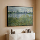 Black floater framed canvas of Banks of the Seine, Vétheuil, 1880 by Claude Monet, featuring an impressionist view of Seine with reflections and greenery above a console cabinet in a minimalist entryway.