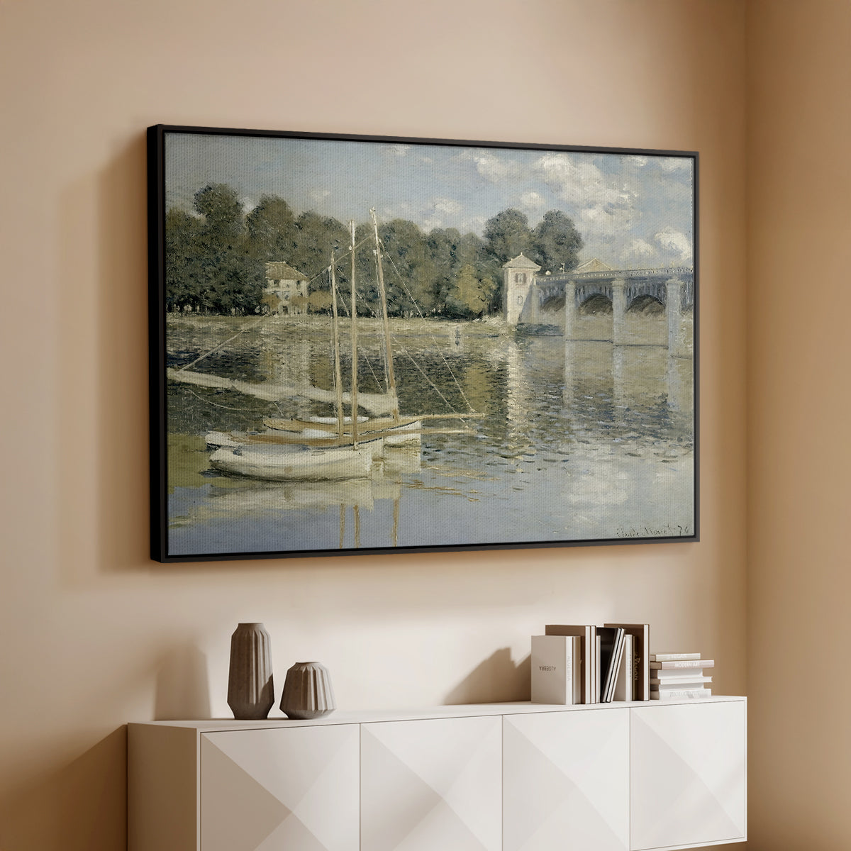 Black floater framed canvas of The Bridge at Argenteuil, 1874 by Claude Monet, featuring an impressionist river scene with boats passing beneath bridge above a console cabinet in a minimalist entryway.
