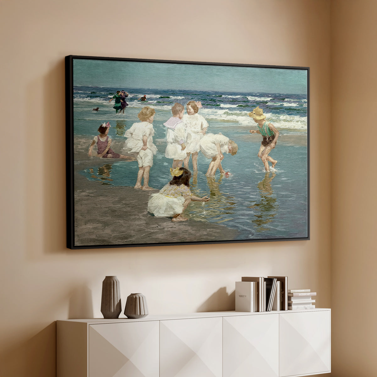 Black floater framed canvas of A Holiday, c. 1915 by Edward Henry Potthast, featuring a beach scene with figures bathing and standing in waves under bright sky above a console cabinet in a minimalist entryway.