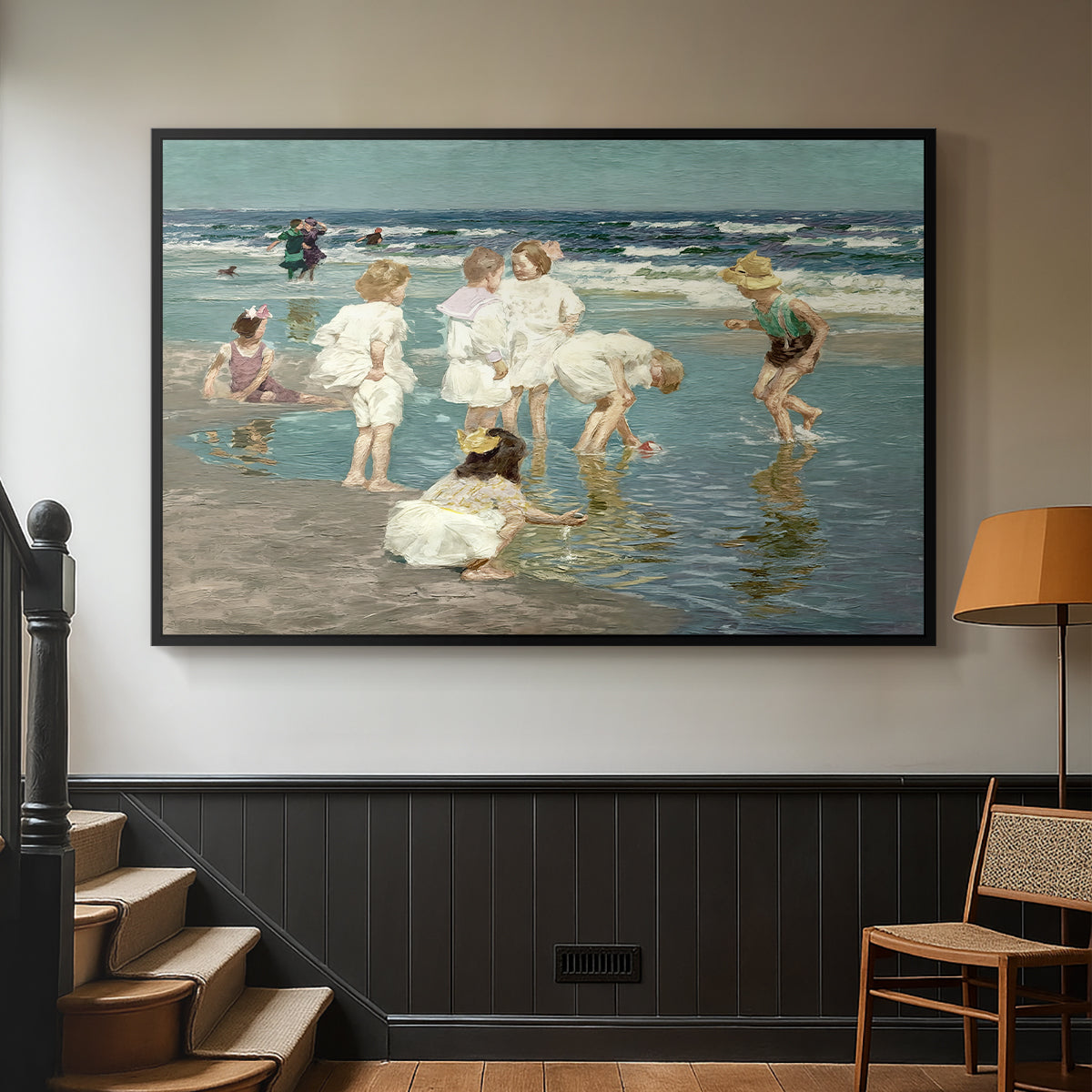 Black floater framed canvas featuring a lively shoreline scene with people gathered in surf, displayed in a hallway near a staircase.