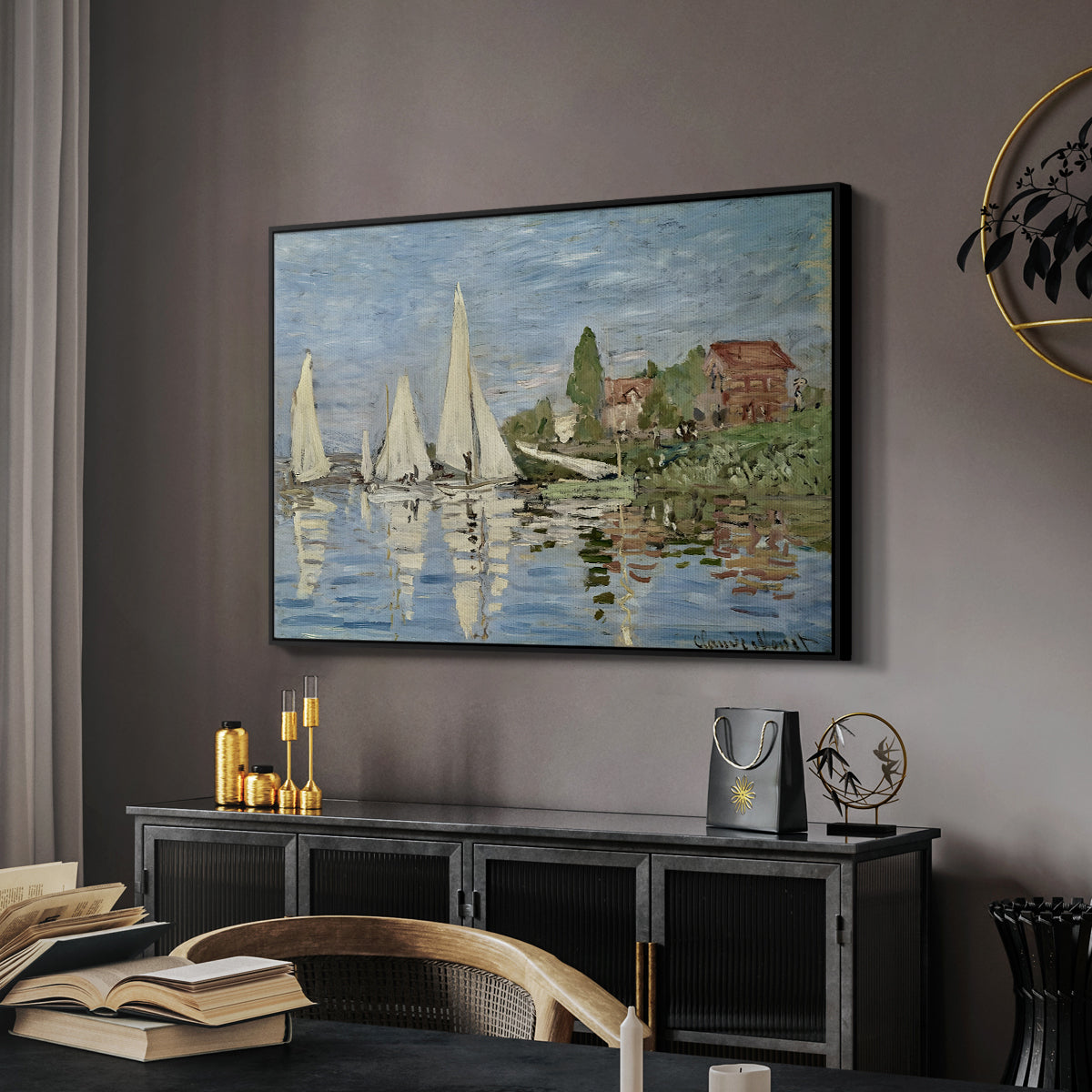 Regatta at Argenteuil, 1872 by Claude Monet in a black floater framed canvas featuring an impressionist depiction of sailing competition on water, displayed above a desk in a dark home office interior.