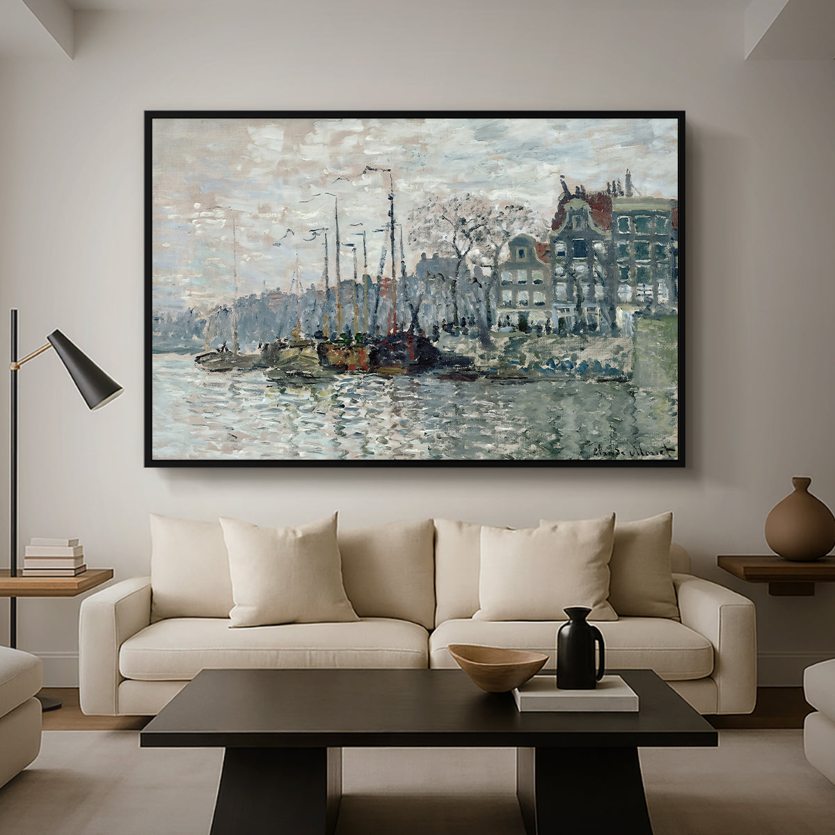View of the Prins Hendrikkade and Kromme Waal in Amsterdam, 1874 by Claude Monet as a black floater framed canvas featuring a canal scene with boats and buildings lining waterfront in Amsterdam, displayed above a sofa in a modern living room.