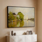 Black floater framed canvas of Houses on the Achterzaan, 1871 by Claude Monet, featuring riverside homes with trees and mirrored reflections in water above a console cabinet in a minimalist entryway.