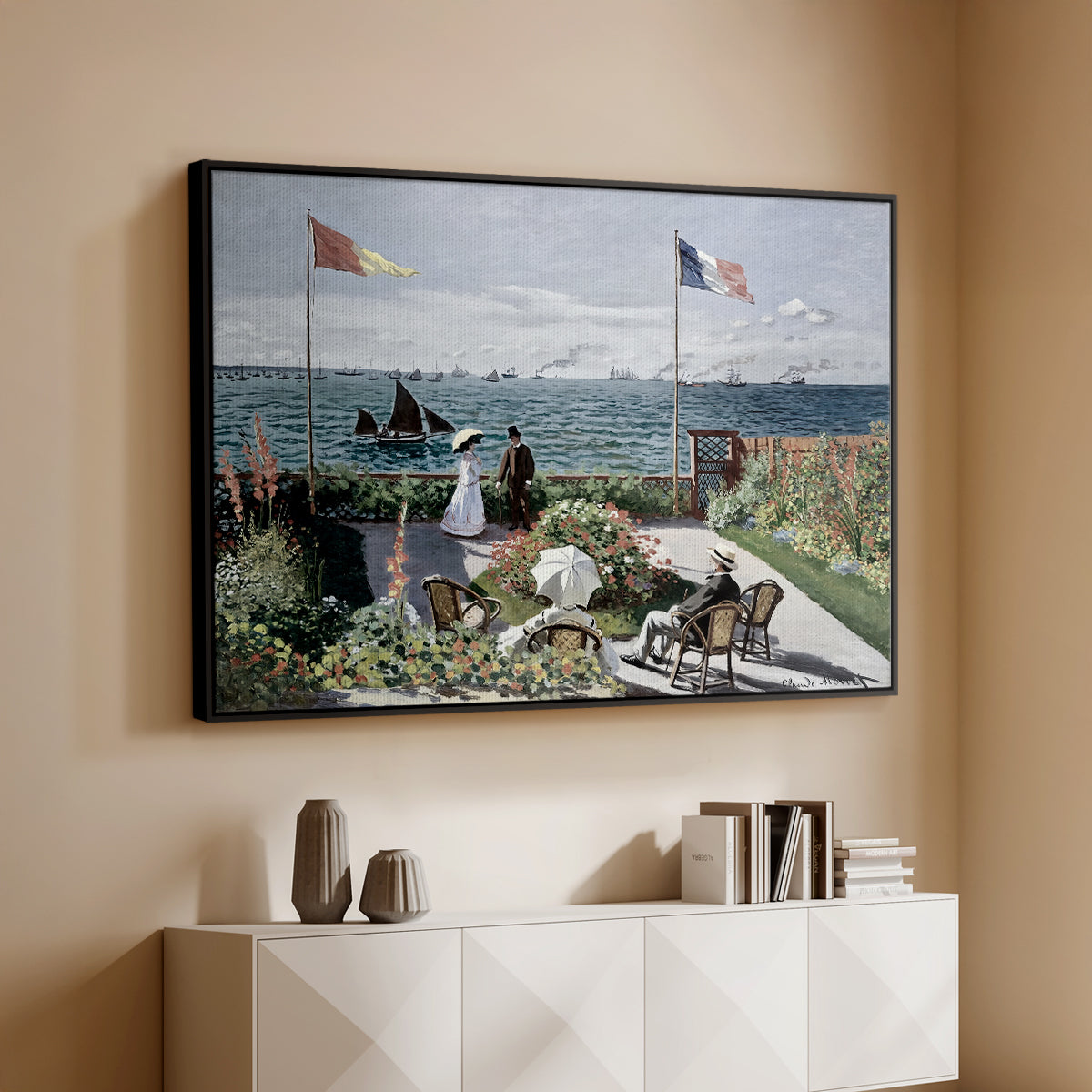 Black floater framed canvas of Garden at Sainte-Adresse, 1867 by Claude Monet, featuring an impressionist coastal garden with people and ocean view above a console cabinet in a minimalist entryway.