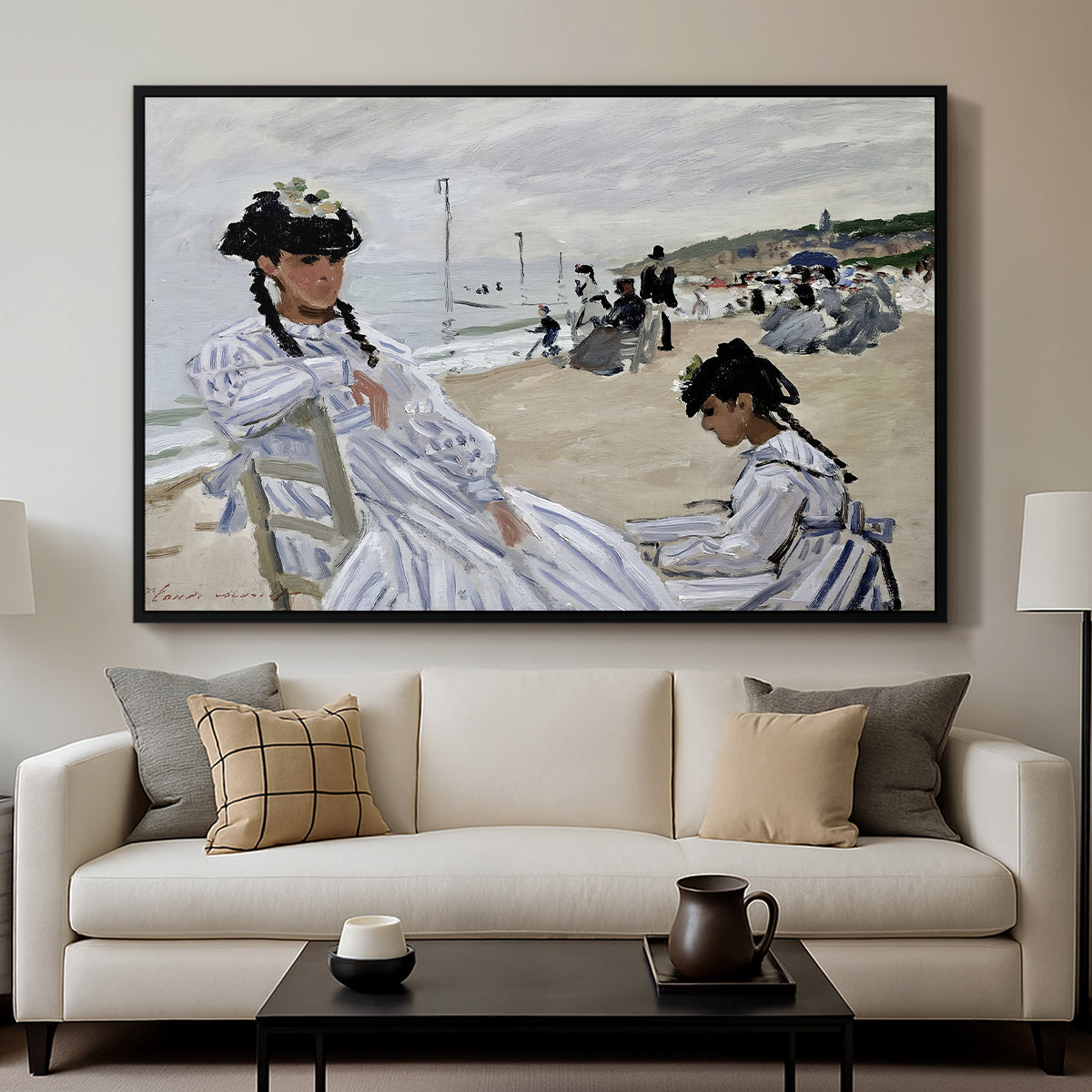 On the Beach at Trouville, 1870 by Claude Monet displayed in a black floater framed canvas above a sofa in a clean living room.