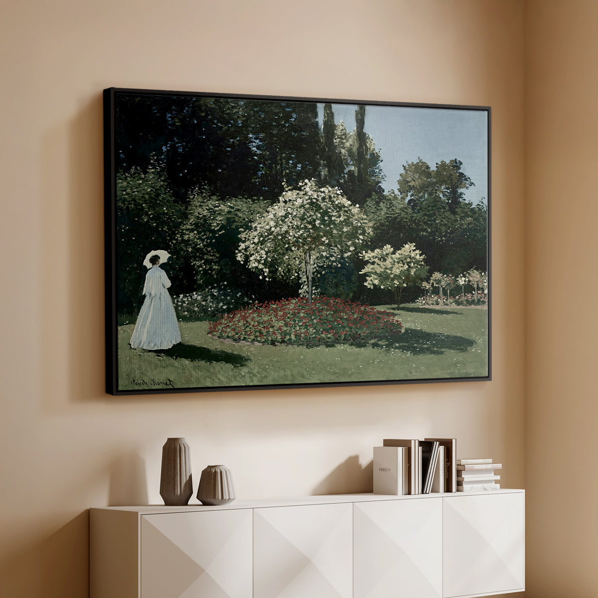 Black floater framed canvas of Woman in the Garden, Sainte-Adresse, 1867 by Claude Monet, featuring an impressionist figure in sunlit garden with lush vegetation above a console cabinet in a minimalist entryway.