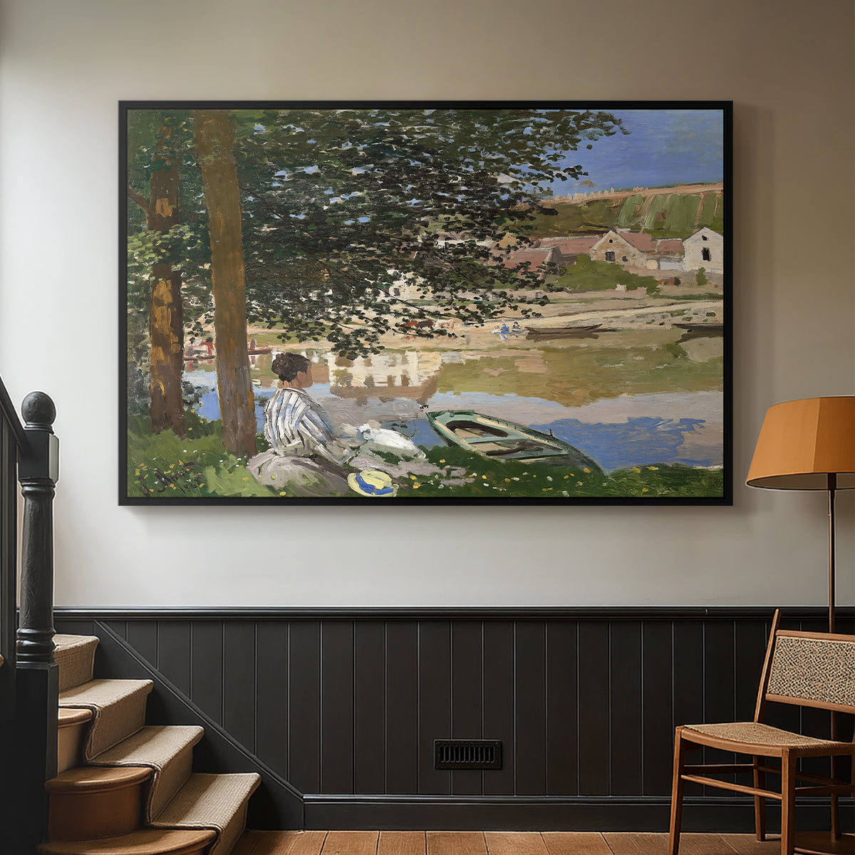 Black floater framed canvas featuring a quiet outdoor setting with figures near river under foliage, displayed in a hallway near a staircase.