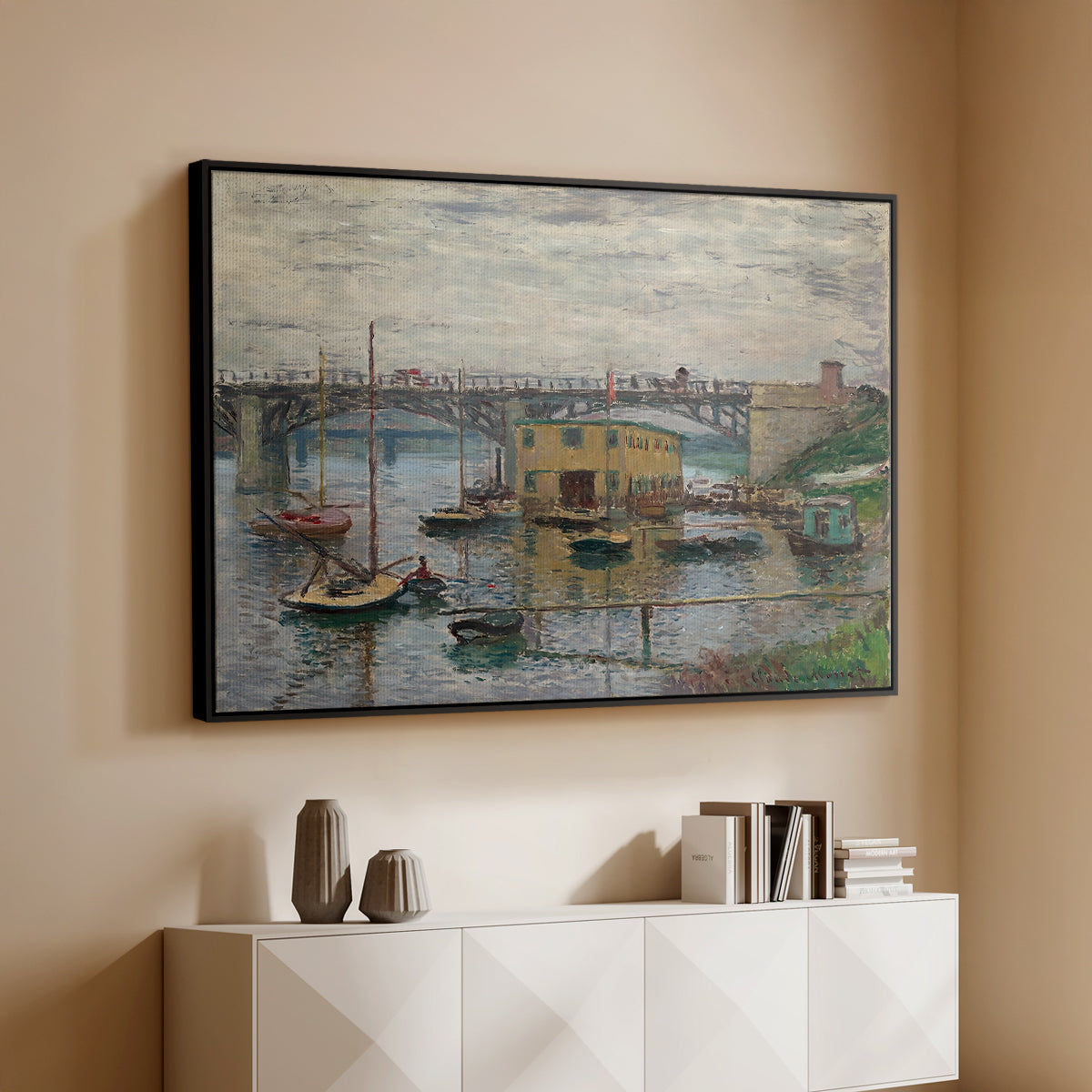 Black floater framed canvas of Bridge at Argenteuil on a Gray Day, c. 1876 by Claude Monet, featuring an impressionist riverscape with overcast atmosphere and soft tones above a console cabinet in a minimalist entryway.