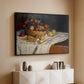 Black floater framed canvas of Still Life with Apples and Grapes, 1880 by Claude Monet, featuring an impressionist still life of fruit placed on cloth-covered surface above a console cabinet in a minimalist entryway.