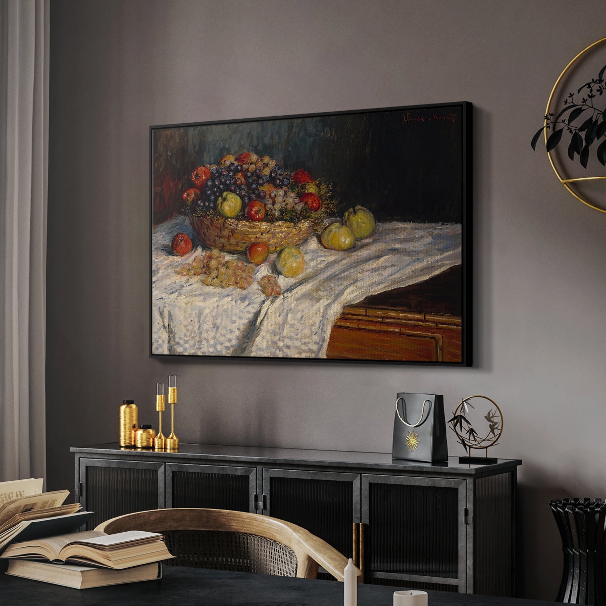 Still Life with Apples and Grapes, 1880 by Claude Monet in a black floater framed canvas featuring a close-up of apples and grapes in warm tones, displayed above a desk in a dark home office interior.