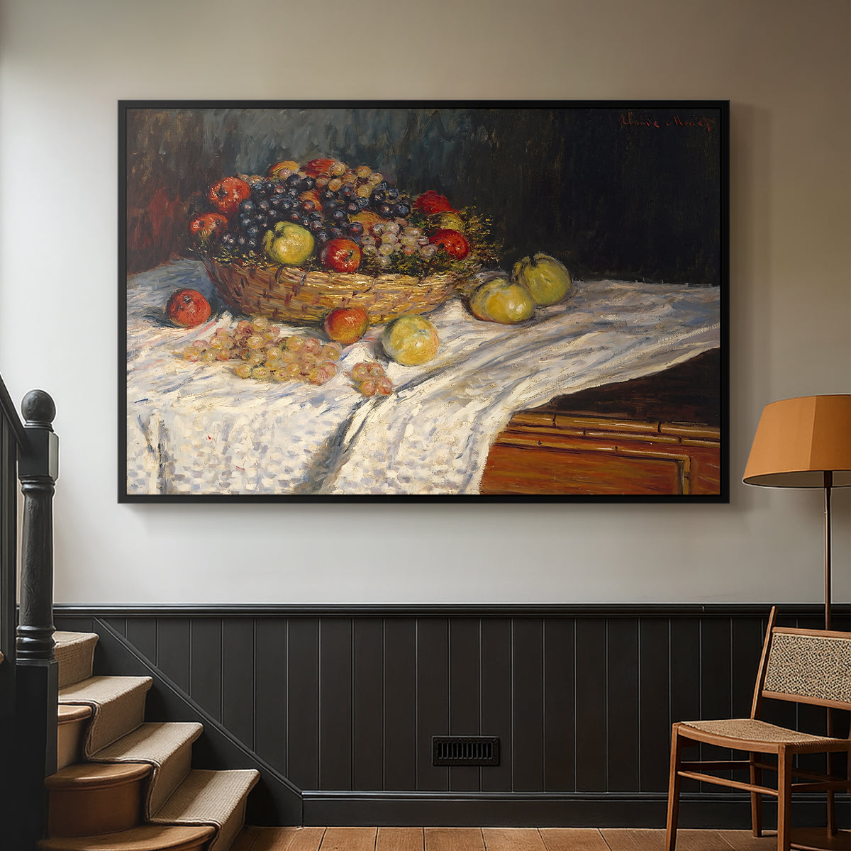 Black floater framed canvas featuring a tabletop composition with fruit and subtle shadows, displayed in a hallway near a staircase.