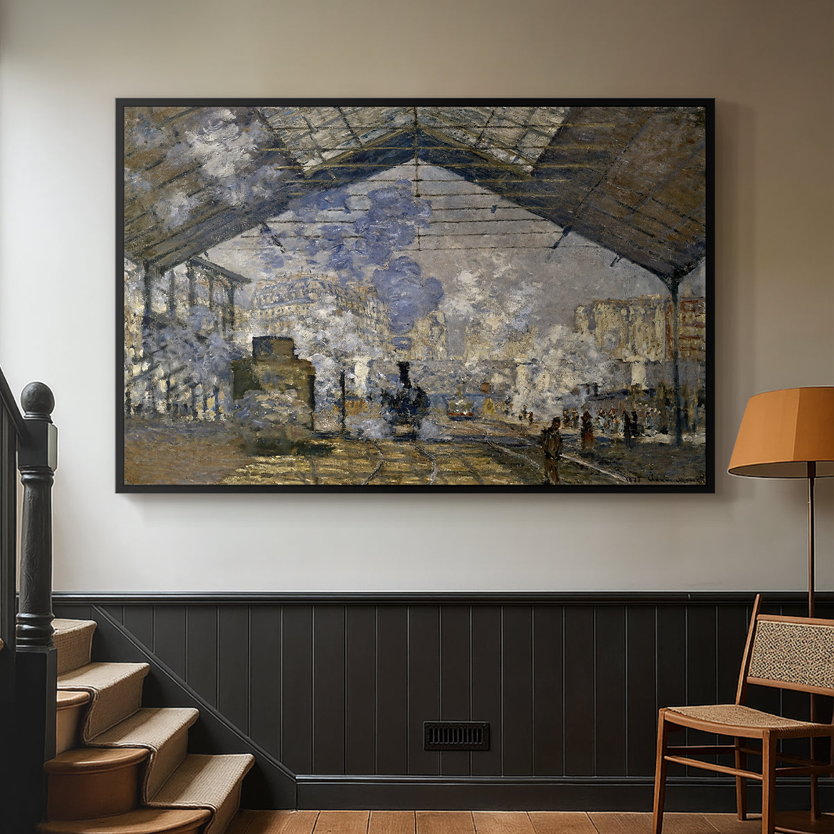 Black floater framed canvas featuring a bustling transport hub with trains beneath glass roof, displayed in a hallway near a staircase.