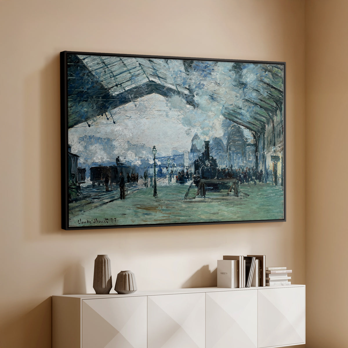 Black floater framed canvas of The Saint-Lazare Station, 1877 by Claude Monet, featuring an impressionist railway scene with locomotives and haze above a console cabinet in a minimalist entryway.