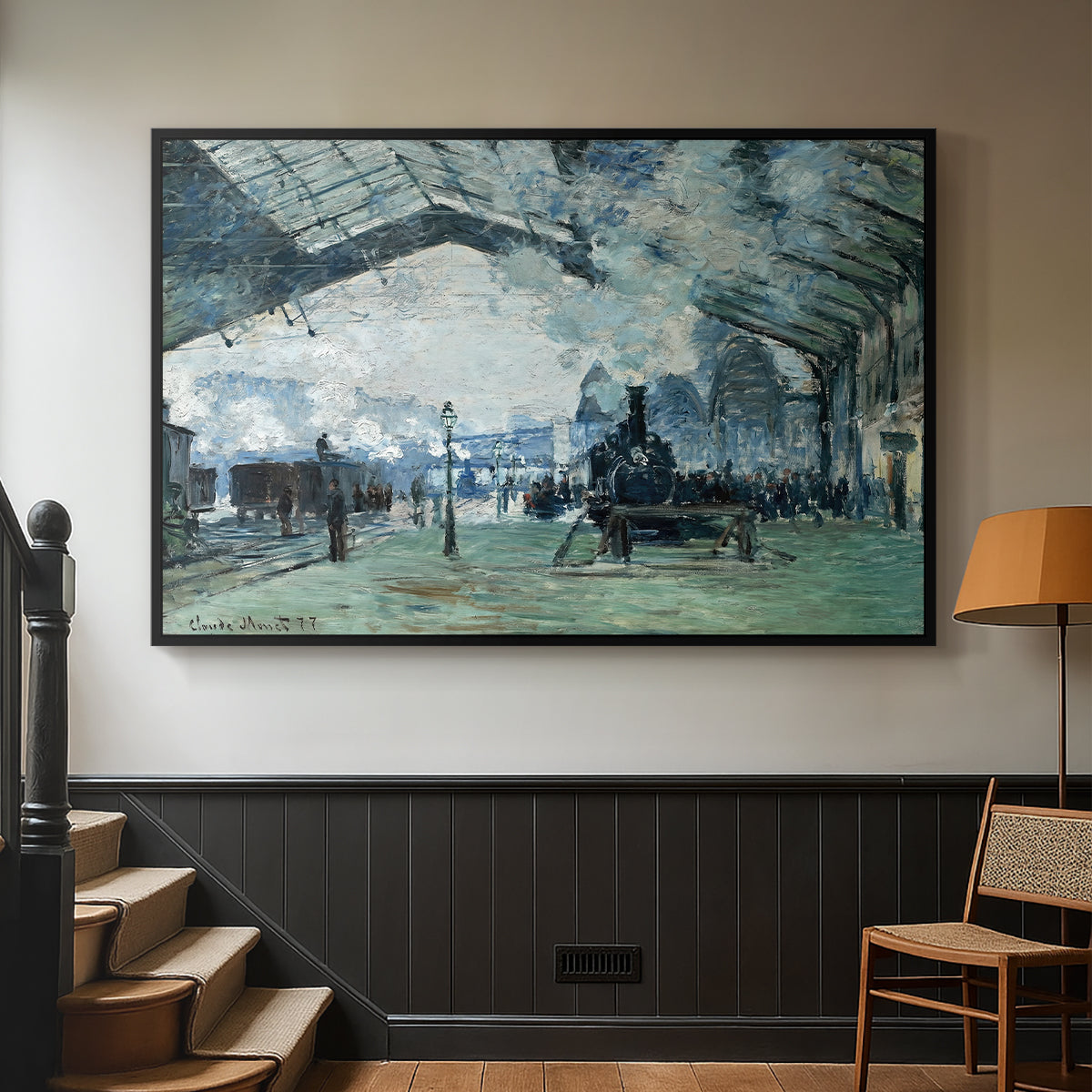 Black floater framed canvas featuring a dramatic depiction of industrial space with trains and light, displayed in a hallway near a staircase.