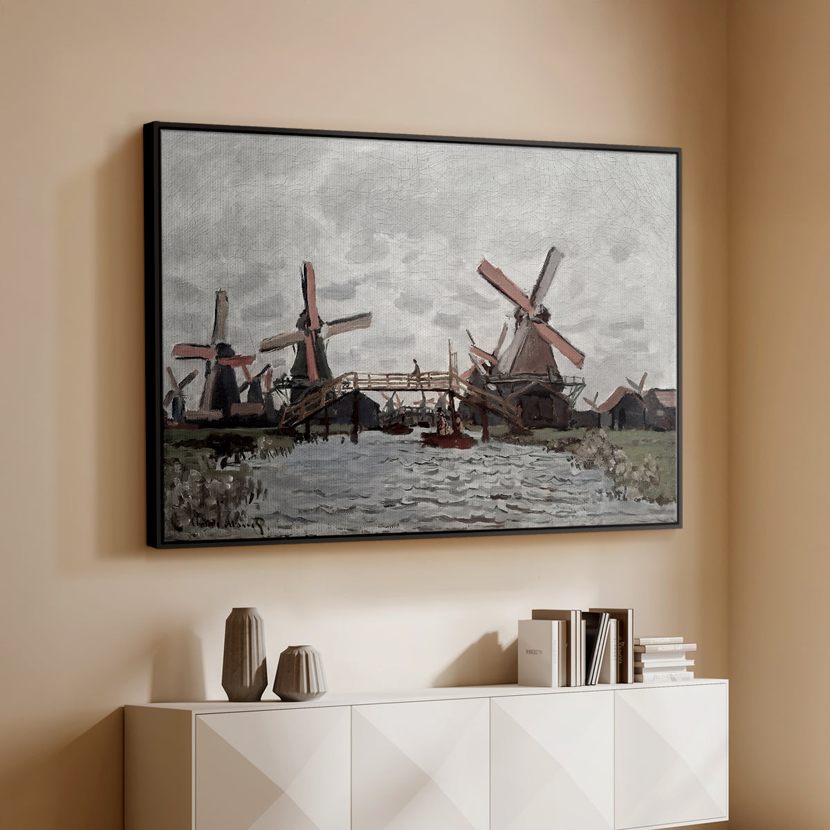 Black floater framed canvas of Windmills near Zaandam, 1871 by Claude Monet, featuring an impressionist view of Dutch windmills along riverbank above a console cabinet in a minimalist entryway.