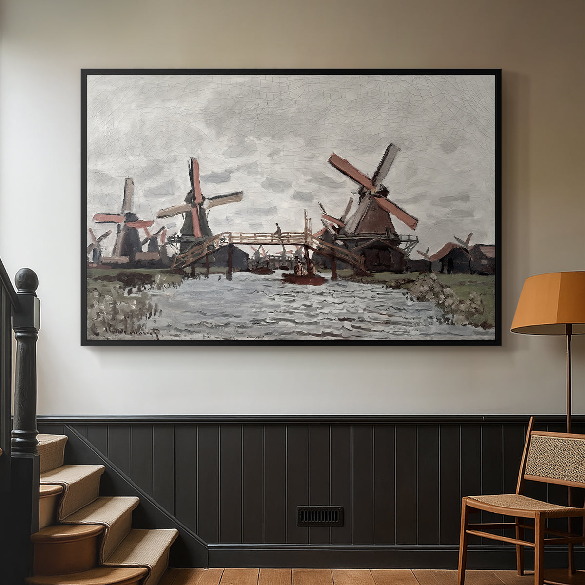 Black floater framed canvas featuring a landscape featuring windmills and low horizon sky, displayed in a hallway near a staircase.