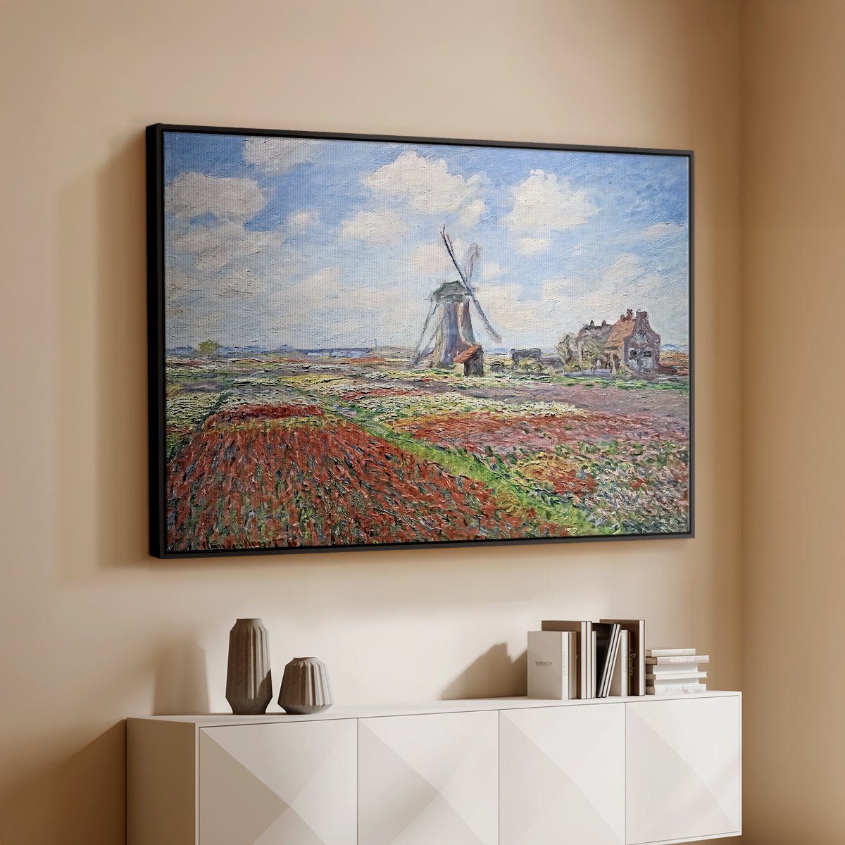 Black floater framed canvas of Tulip Fields with the Rijnsburg Windmill, 1886 by Claude Monet, featuring a vibrant agricultural landscape with flowers and windmill above a console cabinet in a minimalist entryway.